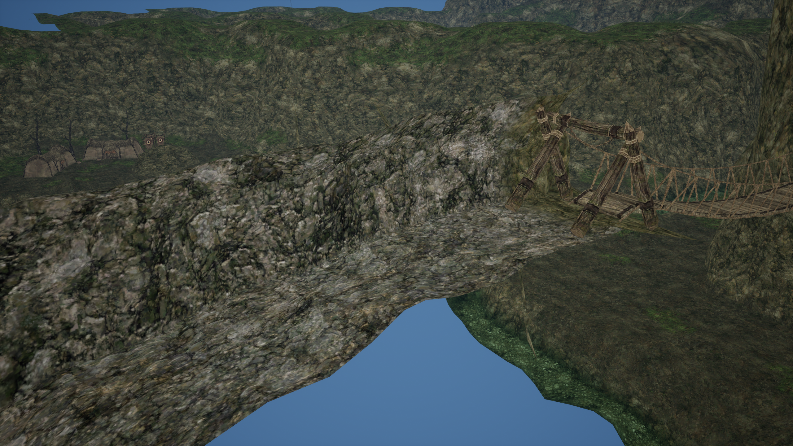 A rope bridge beside rocky terrain and outpost structures in the imported Ghelsba layout, with an unfinished visible boundary beneath